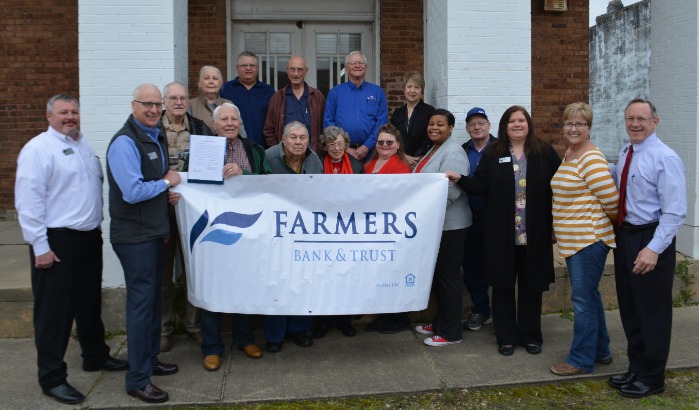 Group smiling outside when FB&T deeds building to city in Blevins, AR